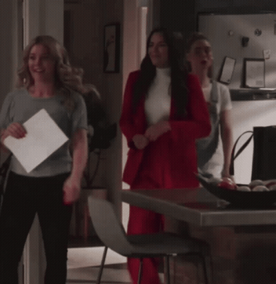 Woman In Red Suit Standing Next To Woman GIF