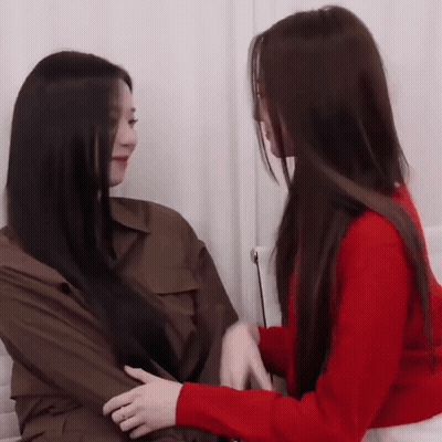 Woman In Red Sweater Holding Another Woman's Arm GIF
