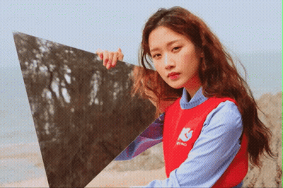 Woman In Red Sweater Holding Triangle In Front Of Face GIF