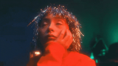 Woman In Red Sweater With Tinsel On Head GIF