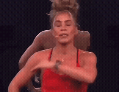 Woman in Red Tank Top Dancing on Stage With Man Behind