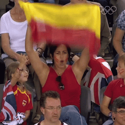 Woman In Red Tank Top Holding Yellow And Red Flag GIF