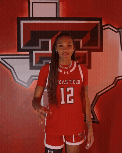Woman In Red Texas Tech Jersey In Front Of Texas Tech Logo GIF