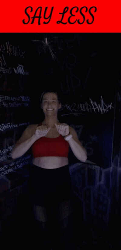 Woman In Red Top And Black Shorts With Say Less Sign GIF