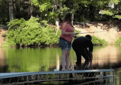 Woman In Red Top Fishing With Man On Dock GIF