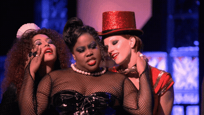 Woman In Red Top Hat Surrounded By Two Women GIF