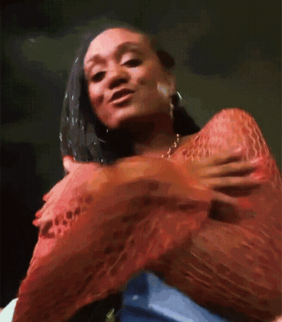 Woman In Red Top Holding Breast GIF