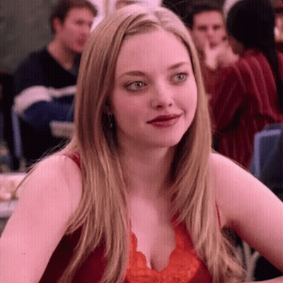 Woman In Red Top Sitting Crowded Room GIF