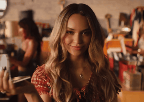 Woman In Red Top Smiling And Holding Cellphone GIF