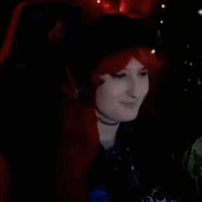 Woman In Red Wig And Headphones Sitting In Chair GIF