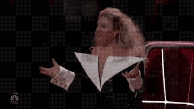 Woman In Revealing White Jacket At Microphone GIF
