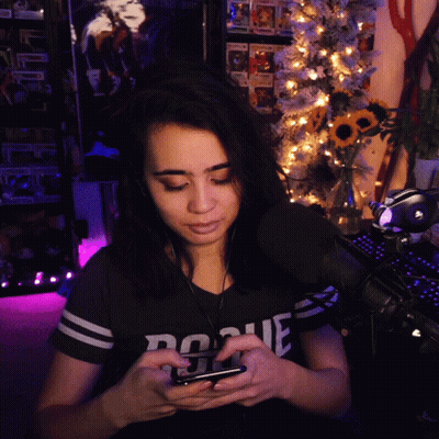 Woman In Rogue Shirt Looking At Phone GIF