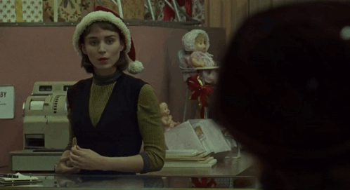Woman In Santa Hat Behind Counter GIF