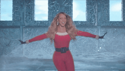 Woman in Santa Outfit Dancing in Front of Window