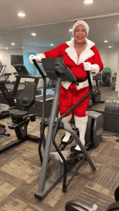 Woman in Santa Suit Riding Elliptical