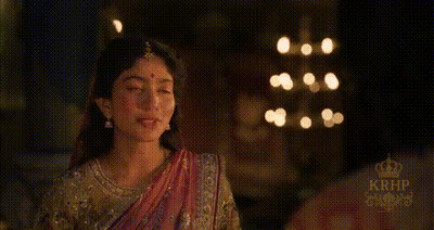 Woman In Sari Standing In Front Of Window With Lights GIF