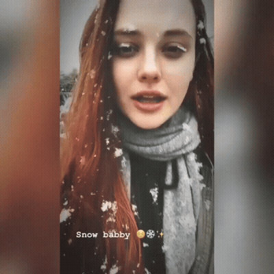 Woman In Scarf Standing In Snow GIF