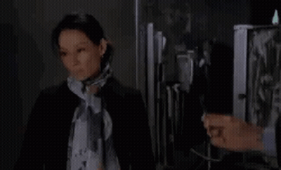 Woman In Scarf Standing Next To Man In Suit In Front Of Fridge GIF