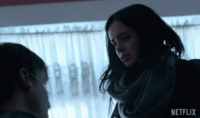 Woman In Scarf Talks To Man In Front Of Window With Netflix Logo GIF