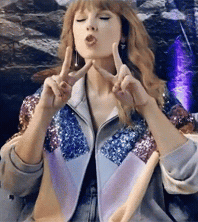 Woman In Sequin Jacket Making Peace Sign GIF