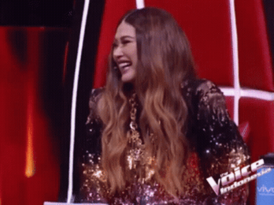Woman In Sequined Dress Laughing On Red Chair GIF