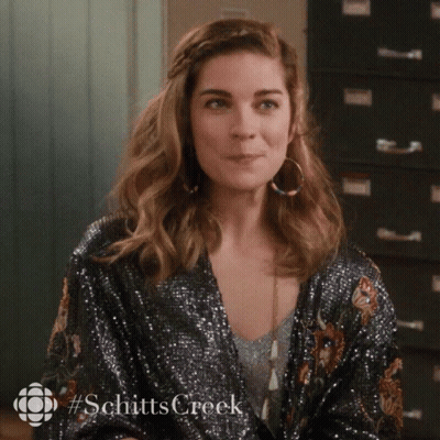 Woman In Sequined Jacket And Hoop Earrings From Schitts Creek GIF