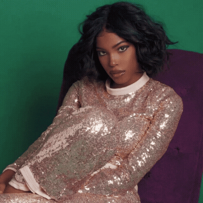 Woman In Sequined Top Sitting In Chair GIF