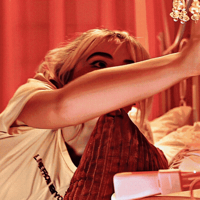 Woman In Shirt Saying L'Amour Sitting On Bed GIF