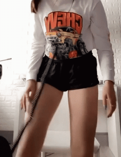Woman In Shorts And Crew Shirt Standing At Desk GIF