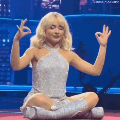 Woman In Silver Dress Sitting With Legs Crossed GIF