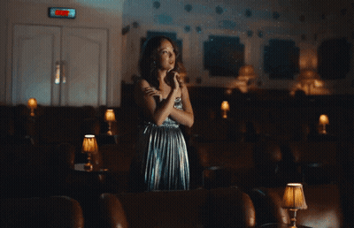 Woman In Silver Dress Under Exit Sign GIF