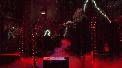 Woman In Skeleton Costume At Microphone In Dark Room GIF