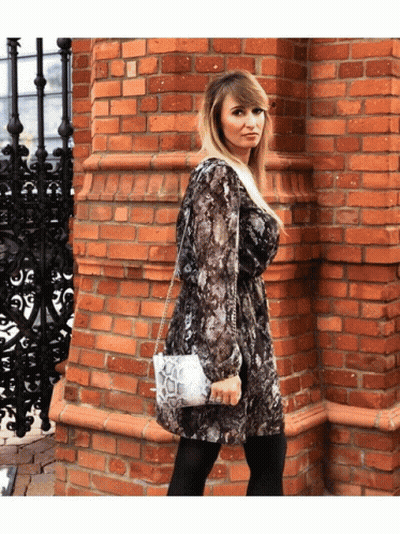 Woman In Snake Print Dress By Brick Wall GIF