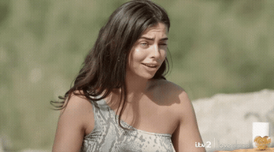 Woman In Snake Print Top In Front Of ITV2 Love Island Sign GIF