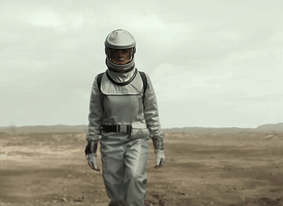 Woman In Space Suit Walking In Desert GIF