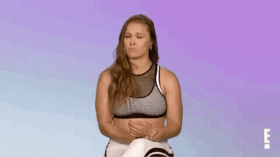 Woman In Sports Bra And Leggings Sitting With Eyes Closed GIF