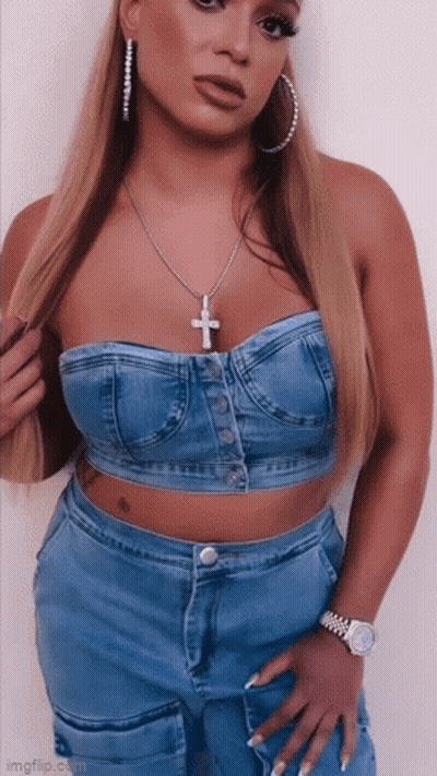 Woman In Strapless Denim Top With Cross Necklace And Hoop Earrings GIF