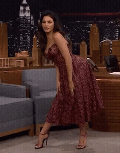 Woman In Strapless Dress Dancing In Front Of Chair GIF