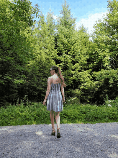 Woman In Striped Dress Walking Gravel Road GIF