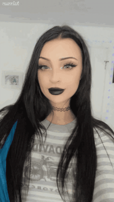 Woman In Striped Motorcycle Shirt And Choker Looking At Camera GIF