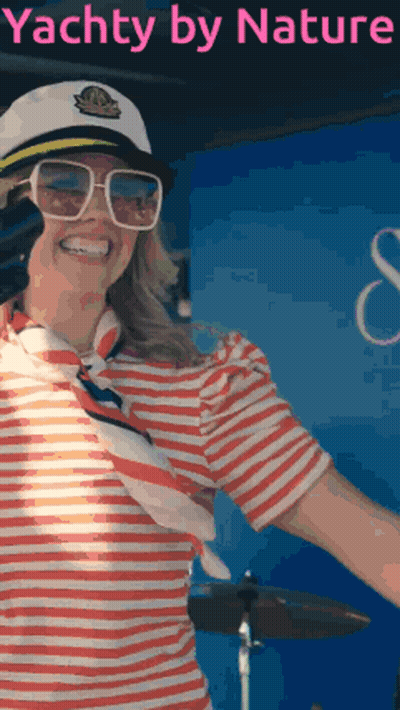 Woman In Striped Shirt And Captain Hat In Front Of Yacht By Nature Sign GIF