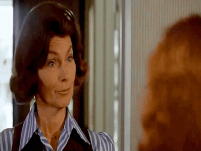 Woman In Striped Shirt And Vest Looking At Woman GIF