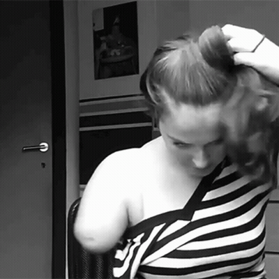 Woman In Striped Shirt Holding Hair Bun GIF