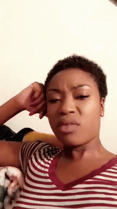 Woman In Striped Shirt Making Funny Face With Hand On Ear GIF