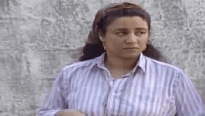 Woman In Striped Shirt Standing By Wall GIF
