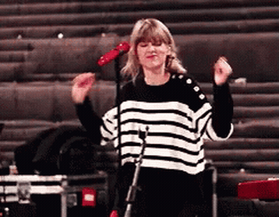 Woman In Striped Sweater Singing Into Microphone GIF
