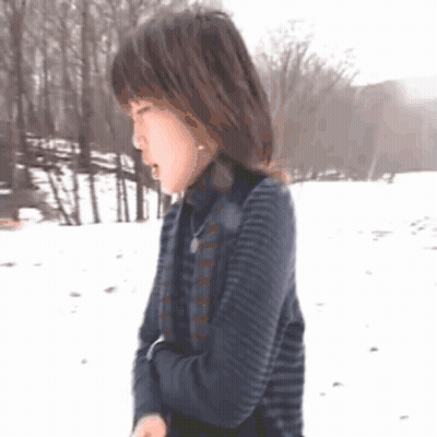 Woman In Striped Sweater Standing In Snow GIF