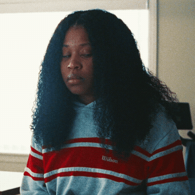 Woman In Striped Wilson Sweatshirt Looking Down GIF
