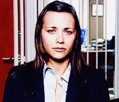 Woman In Suit And Blue Shirt Looking At Camera GIF