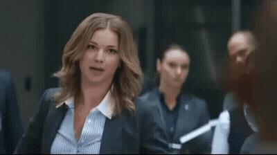 Woman In Suit And Striped Shirt Standing In Room GIF